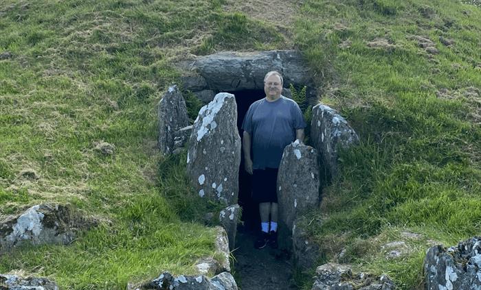 Peter emerges from the interior of Bryn Celli Ddu.
